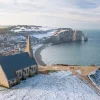 Tableau photo des falaises d'Étretat sous la neige, avec la plage, les falaises et l’arche naturelle en arrière-plan- Décoration murale