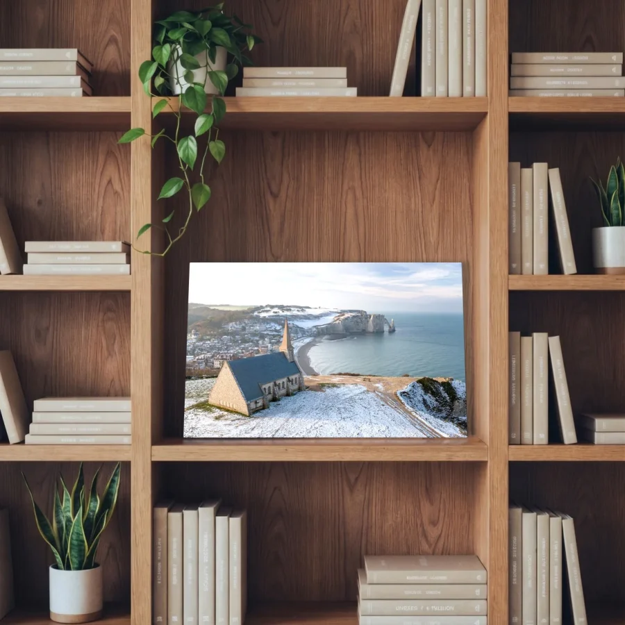 Tableau photo des Falaises d'Etretat sous la neige, au format 20 x 30 cm installé dans une bibliothèque en bois