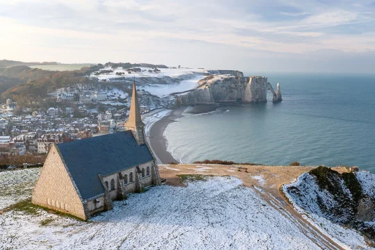 Tableau photo des falaises d'Étretat sous la neige, avec la plage, les falaises et l’arche naturelle en arrière-plan- Décoration murale