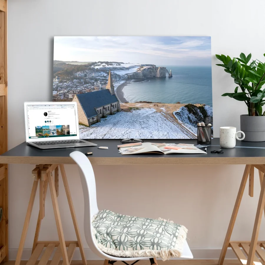 Tableau photo des Falaises d'Etretat sous la neige, au format 60 x 90 cm posé sur un bureau