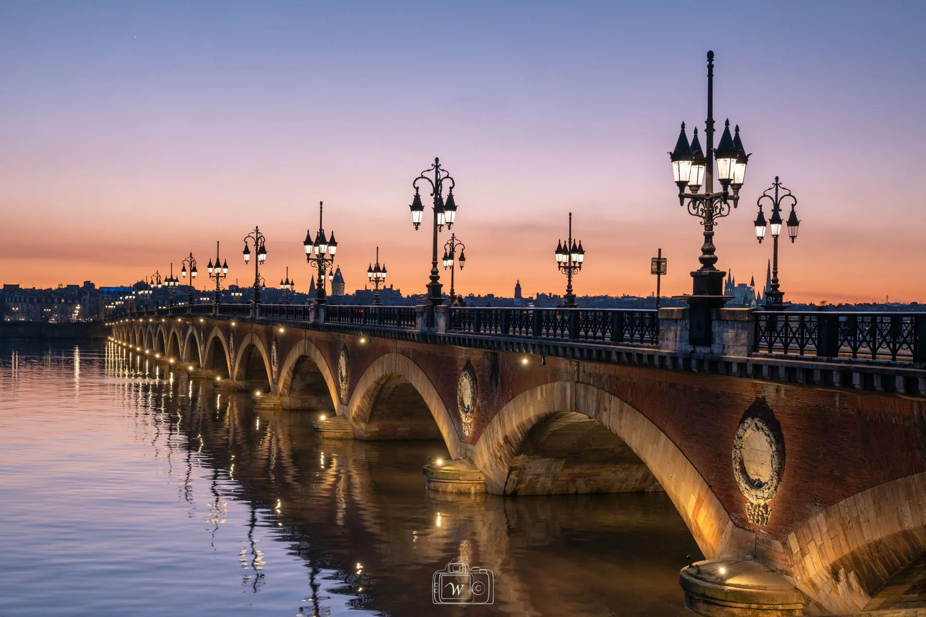Vue sur la chapelle Notre-Dame-de-la-Garde à Étretat sous la neige, avec la plage, les falaises et l’arche naturelle en arrière-plan.